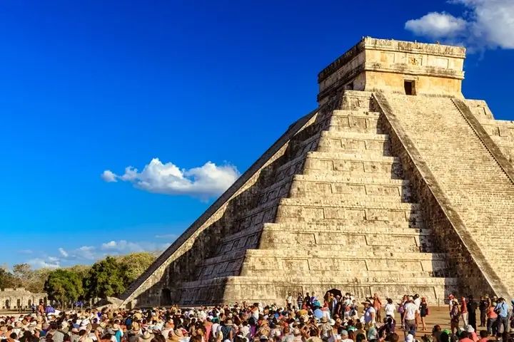 Visitantes frente a la pirámide de Kukulkán en Chichén Itzá