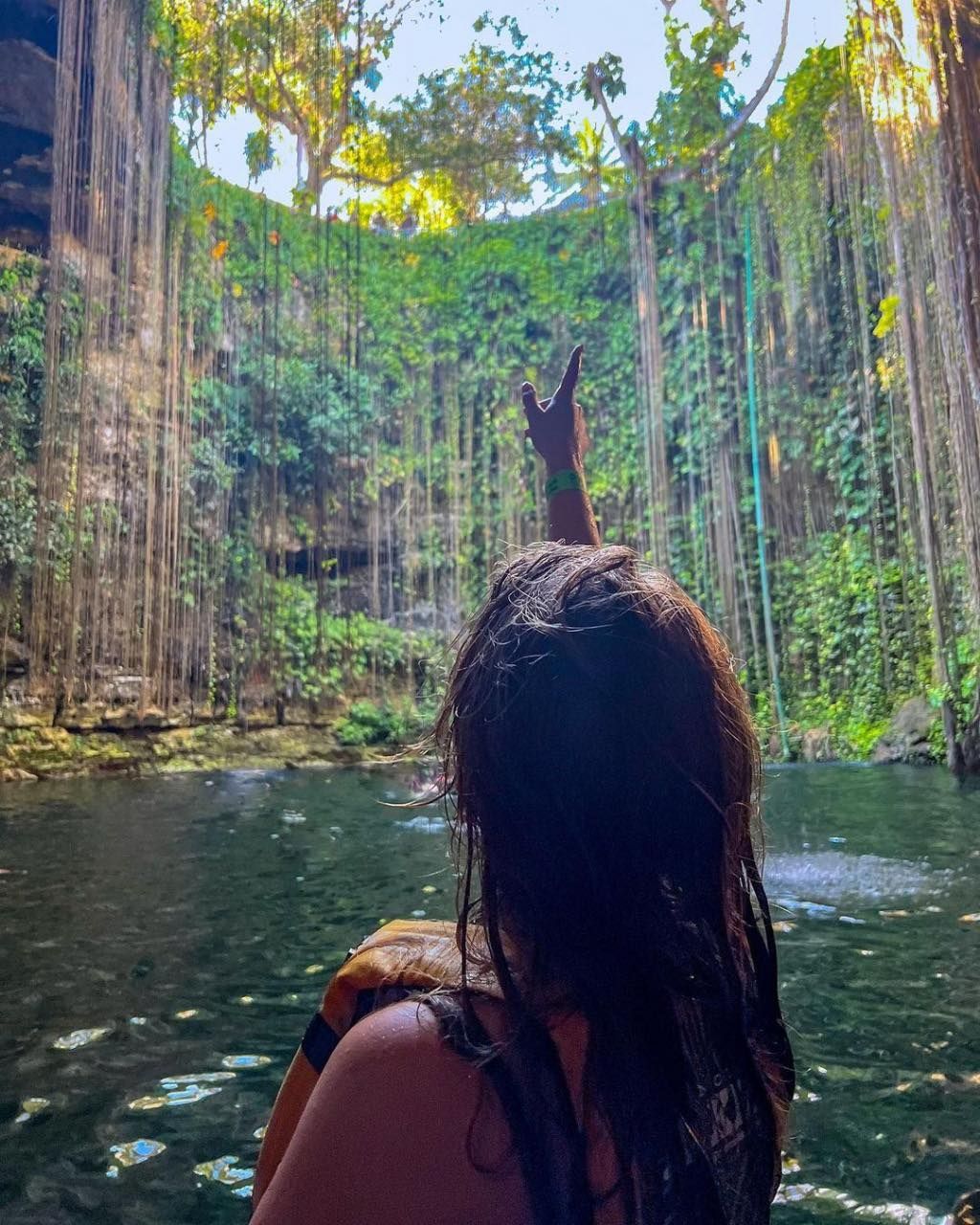 Visitante contemplando las lianas del Cenote Ik Kil